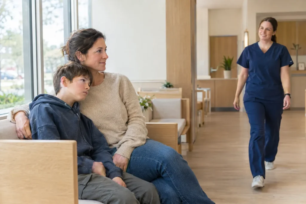 Mother and son waiting side by side in a bright clinic waiting area